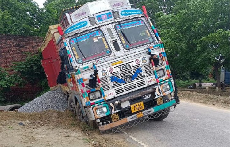 सड़क पर हुए गड्ढे में धंसी ट्रक